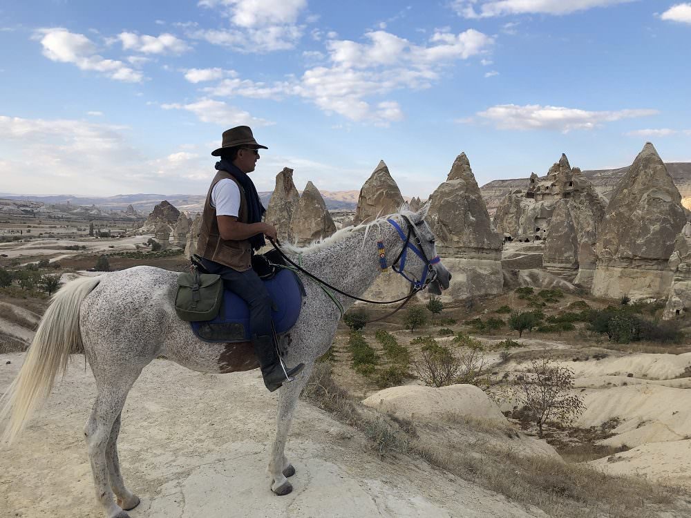 guide erchian on his horse overlooking the fairy chimneys 