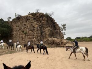 Riding across a dry river bed with part of King Soloman's wall in view